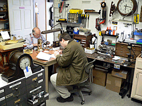 Matt More, foreground, hard at work assembling his timepiece. Tom Bowers, the stores owner, is busy in the background.