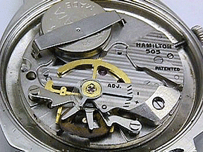 A watch batter inside a watch movement.