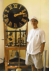 Michael Bowers standing next to a large floor clock at the National Clock and Watch Museum in Columbia, Pennsylvania.